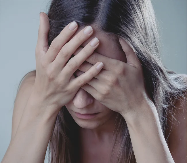 Девушка плачет, закрыв лицо руками
